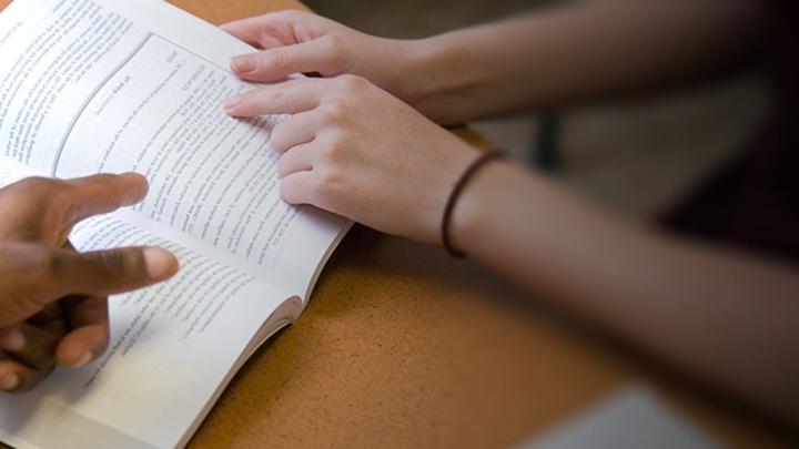 Two english students review text in a book.